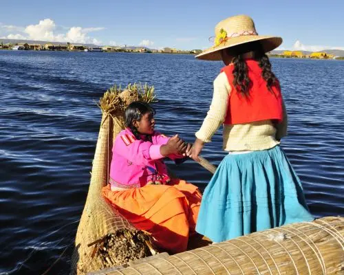 Niños y mujer andina navegando en una embarcación tradicional en el Lago Titicaca