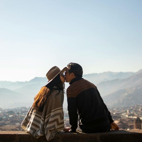 Pareja contemplando la ciudad de Cusco desde el Mirador de San Cristóbal con paisaje andino al fondo