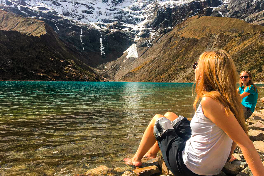 Visitor enjoying the turquoise waters of Humantay Lake in Peru